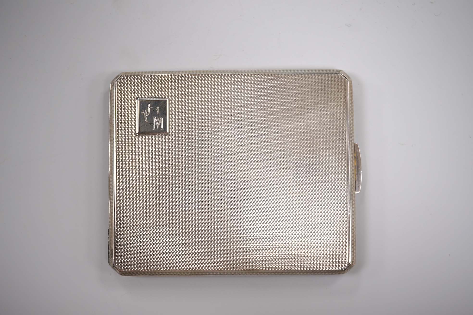 A George V engine turned silver cigarette case by Smith & Bartlam, Birmingham, 1921, a pair of Edwardian silver single handled small dishes by Goldsmiths & Silversmiths Co Ltd and a silver egg cup.